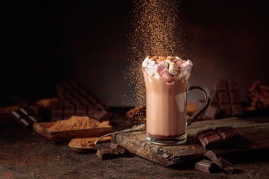 Kakao tozu serpiştirilmiş kremalı sıcak çikolata içeceği. Bir kupa sıcak çikolata, kırık çikolata ve kakao tozu. Boşluğu kopyala.