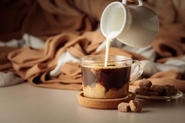 Koyu kahvenin içine krema dök. Latte hazırlanıyor..