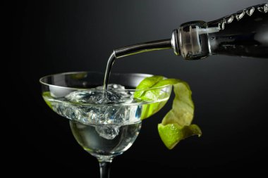 Votka ya da cin buzlu bir bardağa doldurulur. Koyu arkaplanda limon kabuğu olan kokteyl..