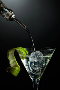 Votka buzlu bir bardağa doldurulur. Buzlu ve limonlu soğuk martini..