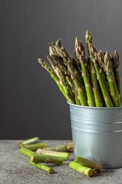 Gri arka planda taze kuşkonmaz. Boşluğu kopyala.