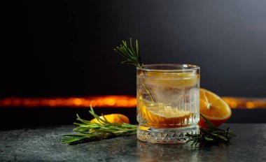 Siyah arka planda limon ve biberiyeli cin tonik kokteyli. Boşluğu kopyala.