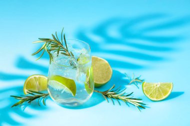 Buzlu, limonlu ve biberiyeli yaz ferahlatıcı içecek. Kopyalama alanı olan mavi arkaplan.