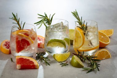 Yaz ferahlatıcı içecekler beyaz mermer bir masada buz, narenciye ve biberiye ile.