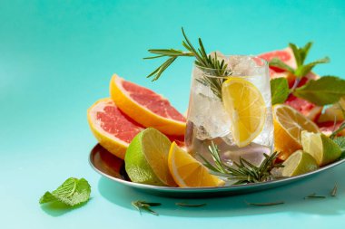 Buz, narenciye, biberiye ve naneli ferahlatıcı bir yaz içeceği. Kopyalama alanı olan yeşil arkaplan.