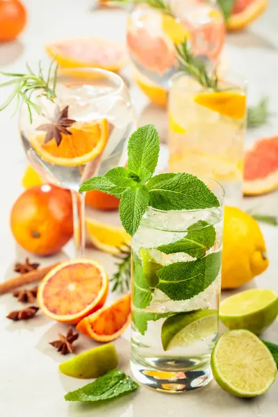 Beyaz mermer bir masada turunçgil ile yaz kokteyllerini tazeliyorum. Buzlu, biberiyeli ve naneli. Önplana odaklan.