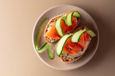 Tütsülenmiş alabalık, krem peynir, salatalık ve bej kapari. Üst görünüm, alanı kopyala.