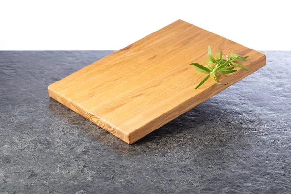 Siyah taşlı arka planda biberiyeli boş kesim tahtası. Boşluğu kopyala.