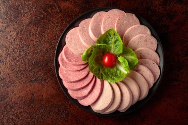 Kahverengi bir arka planda çeşitli haşlanmış sosisler. Boşluğu kopyala.