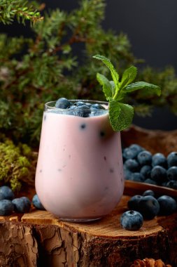 Bardakta yabanmersini püresi ve çam kütüğünde taze böğürtlen. Ormanın kalbinden gelen sağlıklı ekolojik yiyecekler. Ekolojik gıda kavramı.