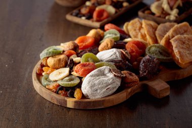 Kurutulmuş tropikal meyve, fındık ve kuru üzümlerin karışımı eski bir ahşap masada..