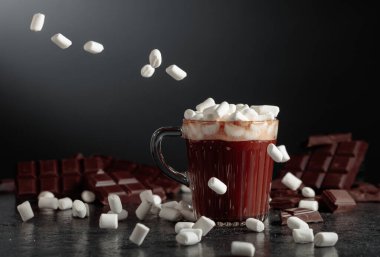 Cam bardakta mini marşmelovlu sıcak çikolata. Kırık bir arka planda acı çikolata.