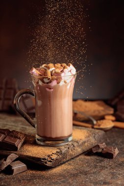 Kakao tozu serpiştirilmiş kremalı sıcak çikolata içeceği. Bir kupa sıcak çikolata, kırık çikolata ve kakao tozu. Boşluğu kopyala.
