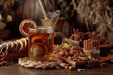 Bir fincan bitkisel çay, çeşitli kurutulmuş bitkiler, çiçekler ve baharatlar. İçindekilerle çay ve kurutulmuş narenciye..