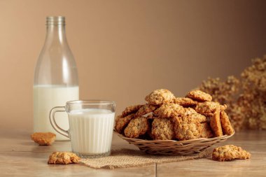 Mutfak masasında yulaflı kurabiye ve süt. Kopyalama alanı olan bej arkaplan.