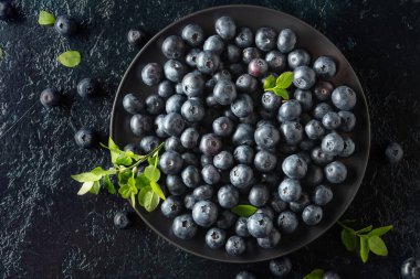 Siyah bir arka planda siyah tabakta yaban mersini. Üst görünüm.