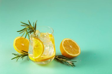 Buzlu, limonlu ve biberiyeli yaz ferahlatıcı içecek. Kopyalamak için yeşil arkaplan.