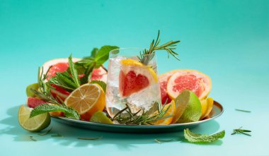 Buz, narenciye, biberiye ve naneli ferahlatıcı bir yaz içeceği. Kopyalama alanı olan yeşil arkaplan.