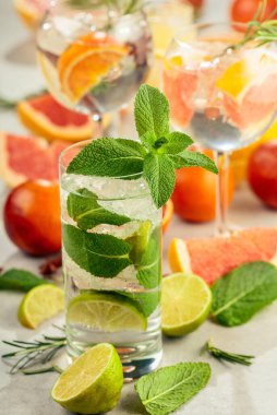 Beyaz mermer bir masada turunçgil ile yaz kokteyllerini tazeliyorum. Buzlu, biberiyeli ve naneli. Seçici odak.