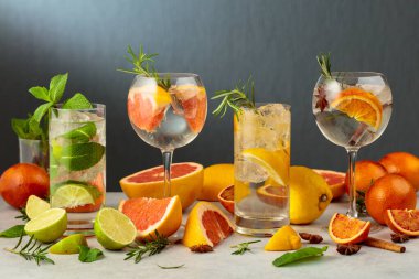 Beyaz mermer bir masada malzemelerle yaz içeceklerini tazeliyorum. Limonlu çeşitli kokteyller..