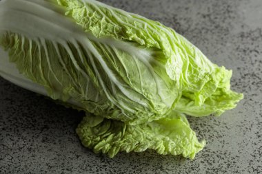 Gri taştan bir masada taze Çin lahanası.