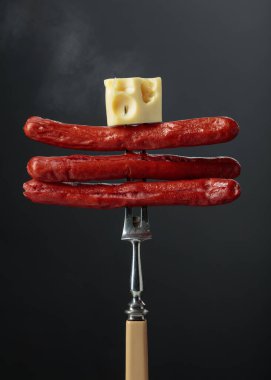 Izgara sosis ve çatal üzerinde peynir..