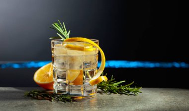 Siyah arka planda limon ve biberiyeli cin tonik kokteyli. Boşluğu kopyala.