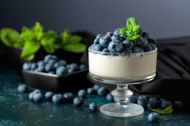 Temiz bir kasede taze yaban mersinli krema. Nane şekeriyle süslenmiş çilekli parfüm..