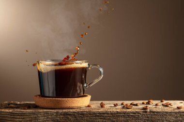 Kahverengi arka planda cam bardakta sade kahve. Boşluğu kopyala.