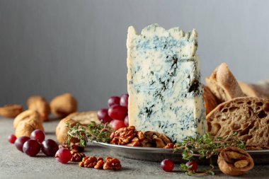 Ciabatta, ceviz, üzüm ve gri taşlı arka planda kekik ile Gorgonzola. Boşluğu kopyala.
