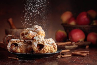 Elma ve tarçınlı ev yapımı mini elmalı turtalar. Üzerine pudra şekeri serpiştirilmiş taze pişmiş yiyecekler. Viyana pastası.