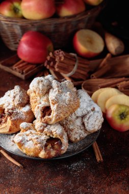Elma ve tarçınlı ev yapımı mini elmalı turtalar. Üzerine pudra şekeri serpiştirilmiş taze pişmiş yiyecekler. Viyana pastası.