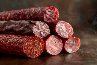 Eski ahşap bir masada tütsülenmiş ve kurutulmuş sosisler..