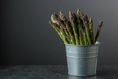 Siyah taş bir masada taze kuşkonmaz. Boşluğu kopyala.