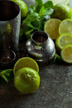 Titretici, limon ve taş bir masada taze nane dalları. Yaz ferahlatıcı içecekler hazırlamak için gerekli malzemeler.