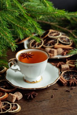 Baharatlı Noel çayı ve eski ahşap bir masada kurutulmuş narenciye dilimleri..