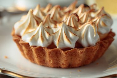 Beyaz bir fincan üzerinde kremalı tart yakın plan..