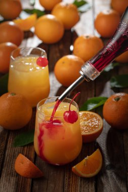 Klasik tekila gündoğumu kokteyli, portakal suyu ve nar şurubu katmanlı, bir şişe maraska kirazıyla süslenmiş. Grenadine kokteyl ile bardağa doldurulur..