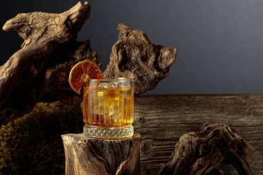 Eski moda bir karışım, buz ve kurutulmuş portakal dilimi ile eski ahşap bir kütükte.. 