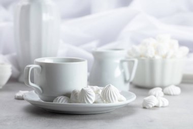 Beyaz vanilyalı krema ve kahve fincanı beyaz mermer bir masada..