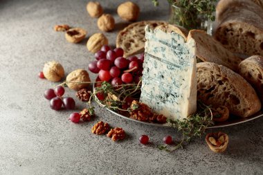 Ciabatta ile Gorgonzola, ceviz, üzüm ve gri taşlı arka planda kekik..