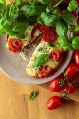 Nefis, açık sandviçler, mozarella peyniri, domates, fesleğen ve baharatlar ahşap bir masada..