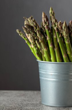 Gri arka planda taze kuşkonmaz. Boşluğu kopyala.