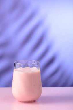 Pembe smoothie, vitamin içeceği ya da renkli bir arkaplanda yoğurt. Boşluğu kopyala.