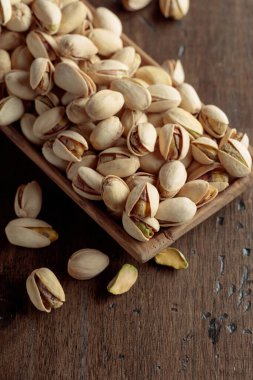 Eski ahşap bir masada tuzlu şam fıstığı.