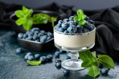 Temiz bir kasede taze yaban mersinli krema. Nane şekeriyle süslenmiş çilekli parfüm..