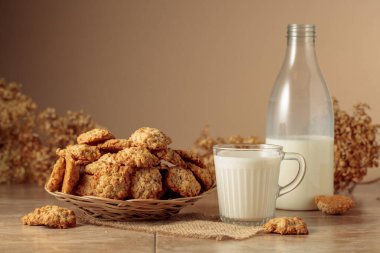 Mutfak masasında yulaflı kurabiye ve süt. Kopyalama alanı olan bej arkaplan.