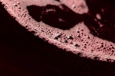 Bardakta kırmızı şarap. Seçici bir odaklanma ile makro çekim. Boşluğu kopyala.