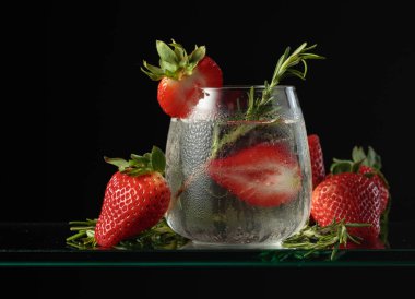 Buzlu, çilekli ve biberiyeli kokteyl cin toniği..