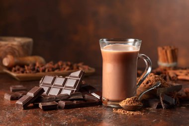 Kahverengi bir şarap masasında acı çikolata ve bir bardak kakao. Boşluğu kopyala.